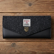 Harris Tweed clasp purse in black herringbone on wooden surface