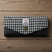 Black and white dogtooth Harris Tweed clasp purse on wooden surface