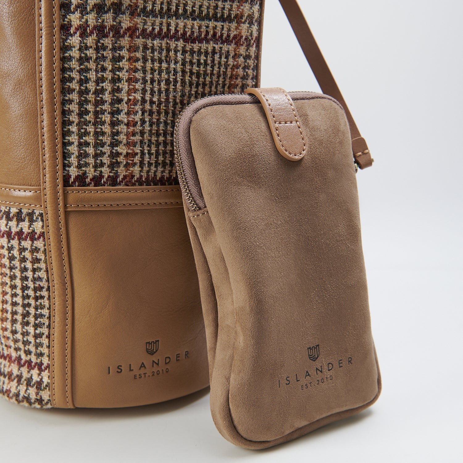 Beige dogtooth bucket bag close-up with matching phone pouch on white