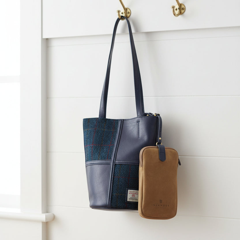 Orlagh navy over-check Harris Tweed bucket bag hanging on wall hook