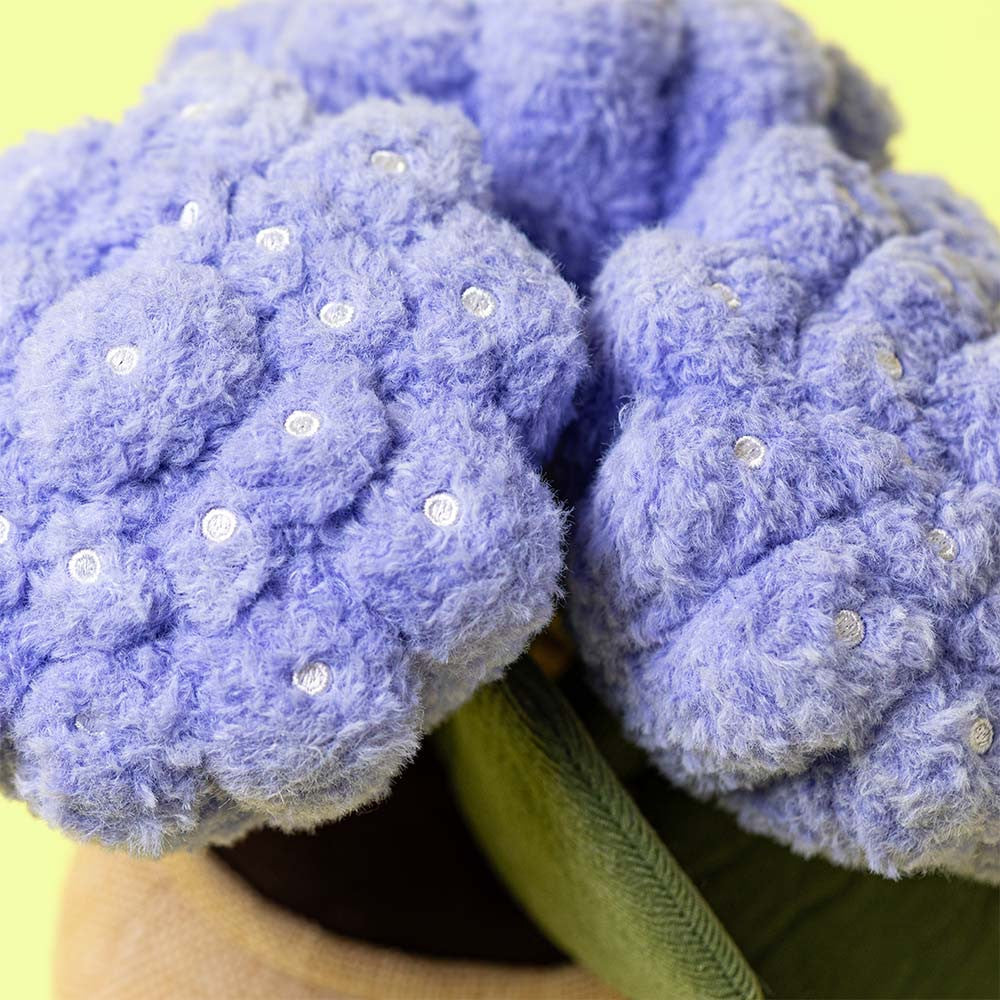 Close-up of fluffy lilac hydrangea petals with white centres on yellow background