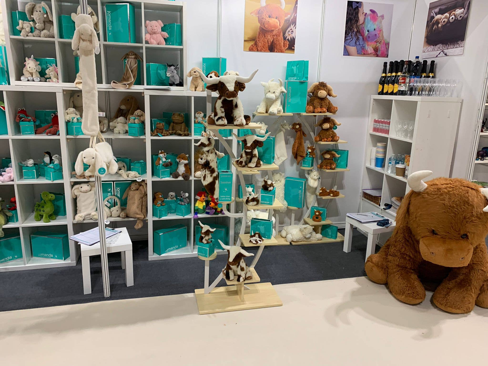 Jomanda display stand featuring longhorn plush cows and teal boxes