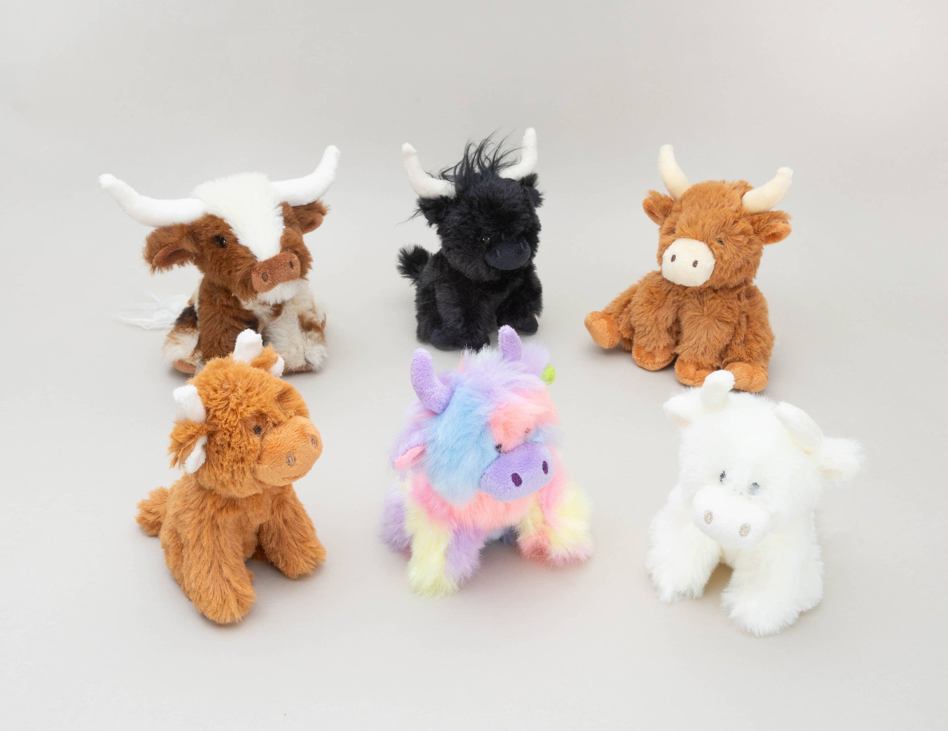Mini soft toy cow collection including Texas Longhorn on pale grey background