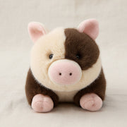 Brown and cream spotty pig soft toy front view on cream linen background