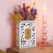 Floral book vase styled with dried flowers on wooden shelf with pink candle