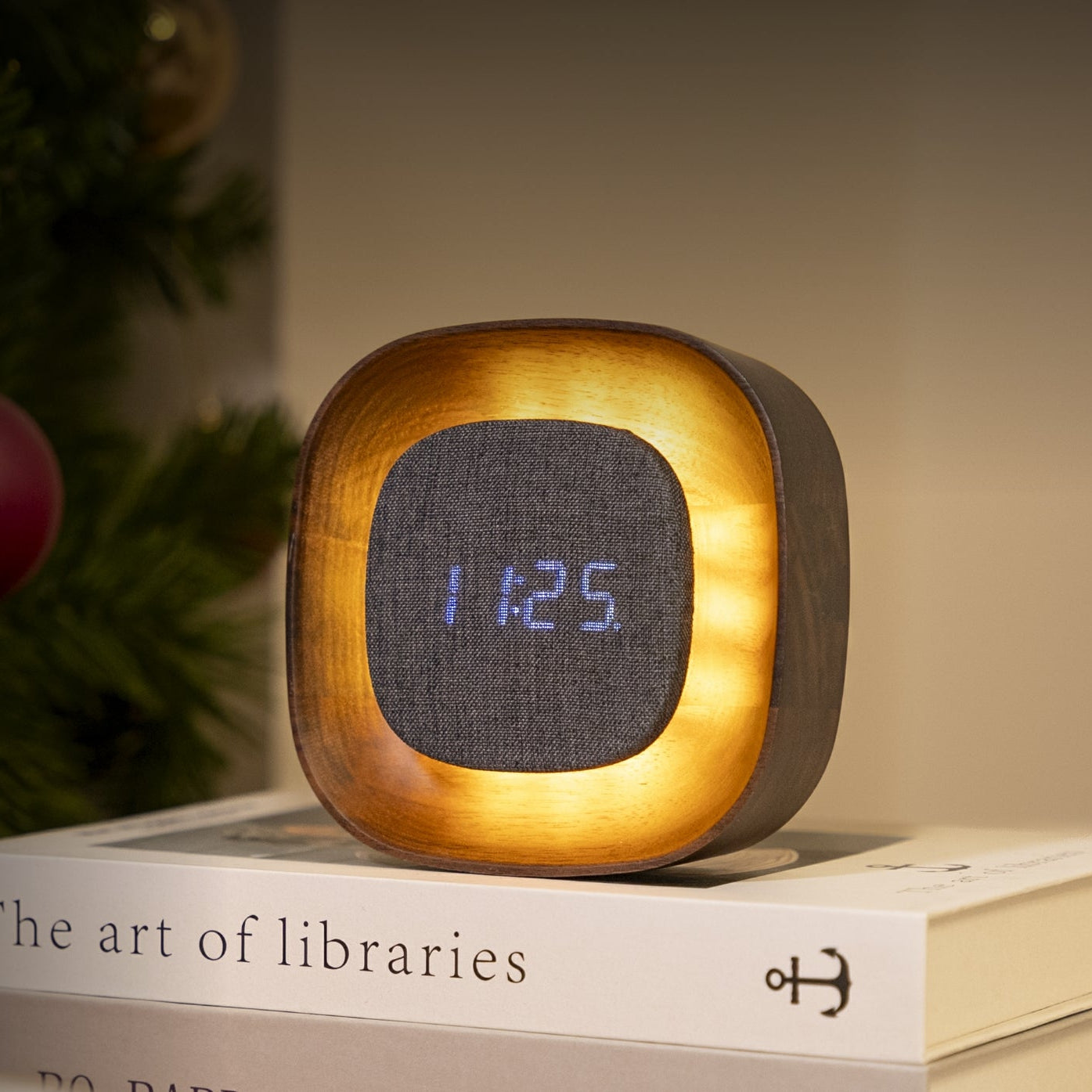 Square walnut Lumos clock lit beside Christmas tree