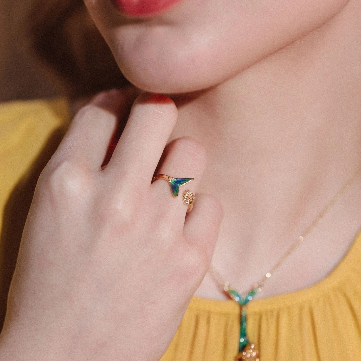 Model wearing Bill Skinner Mermaid Tail Ring with matching necklace, styled with yellow blouse.