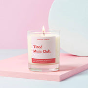 Tired Mum Club candle lit in clear glass with Pink Blossom label