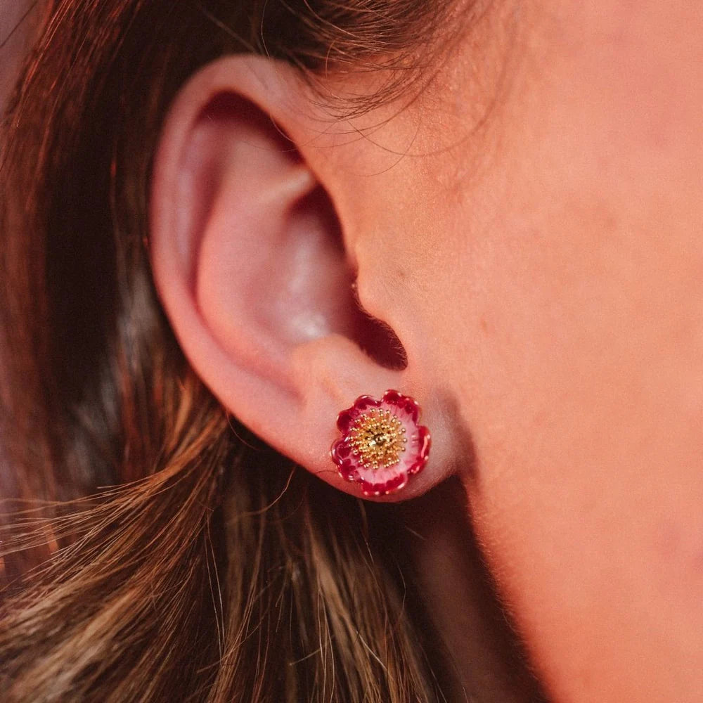 Model wearing Wild Flower Stud Earrings showing delicate floral enamel detail and gold finish.