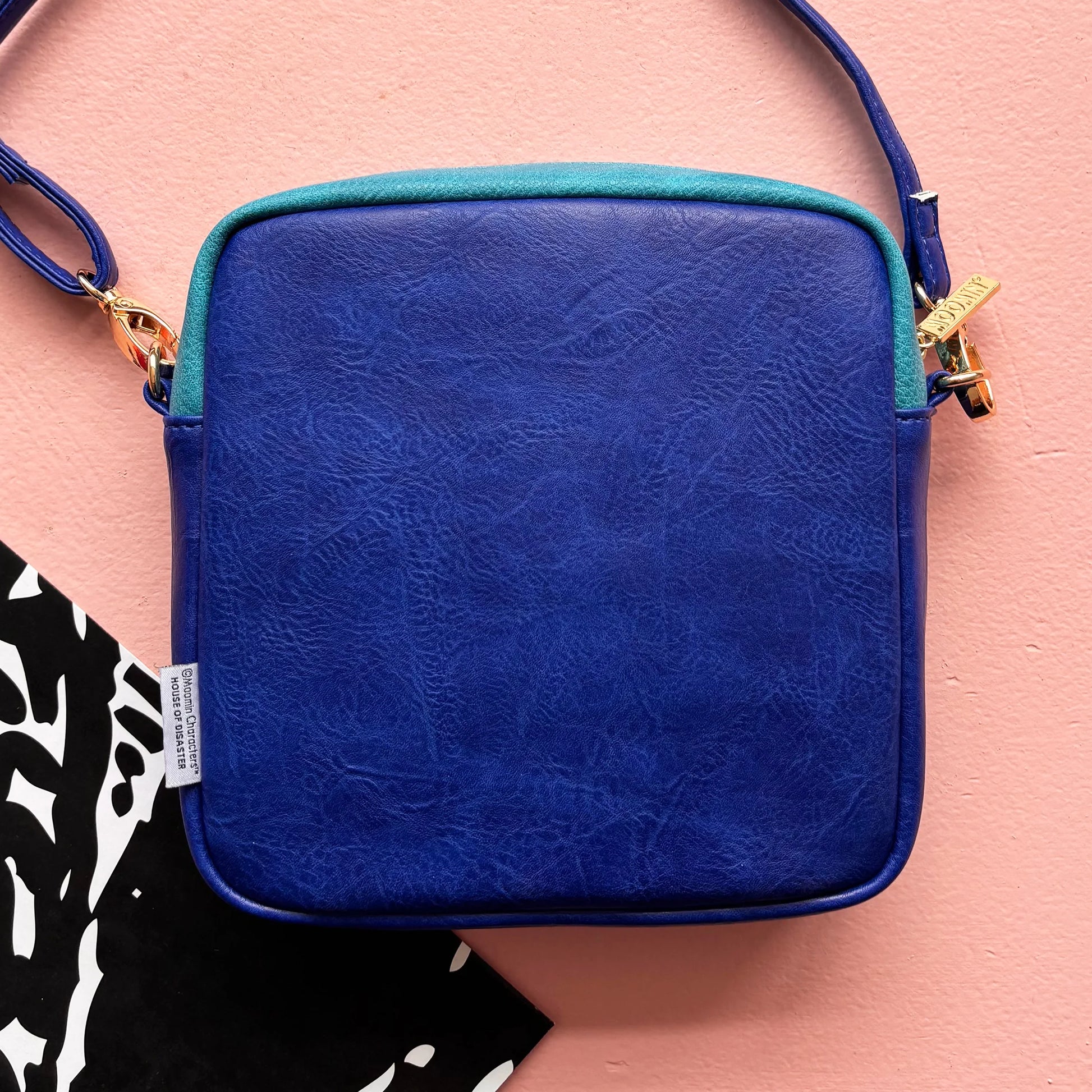 Back view of Moomin Gold Mini Bag showing smooth cobalt blue panel.
