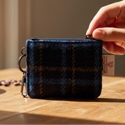 Navy tartan Harris Tweed card zip wallet with zip closure and keyring attachment on white background.
