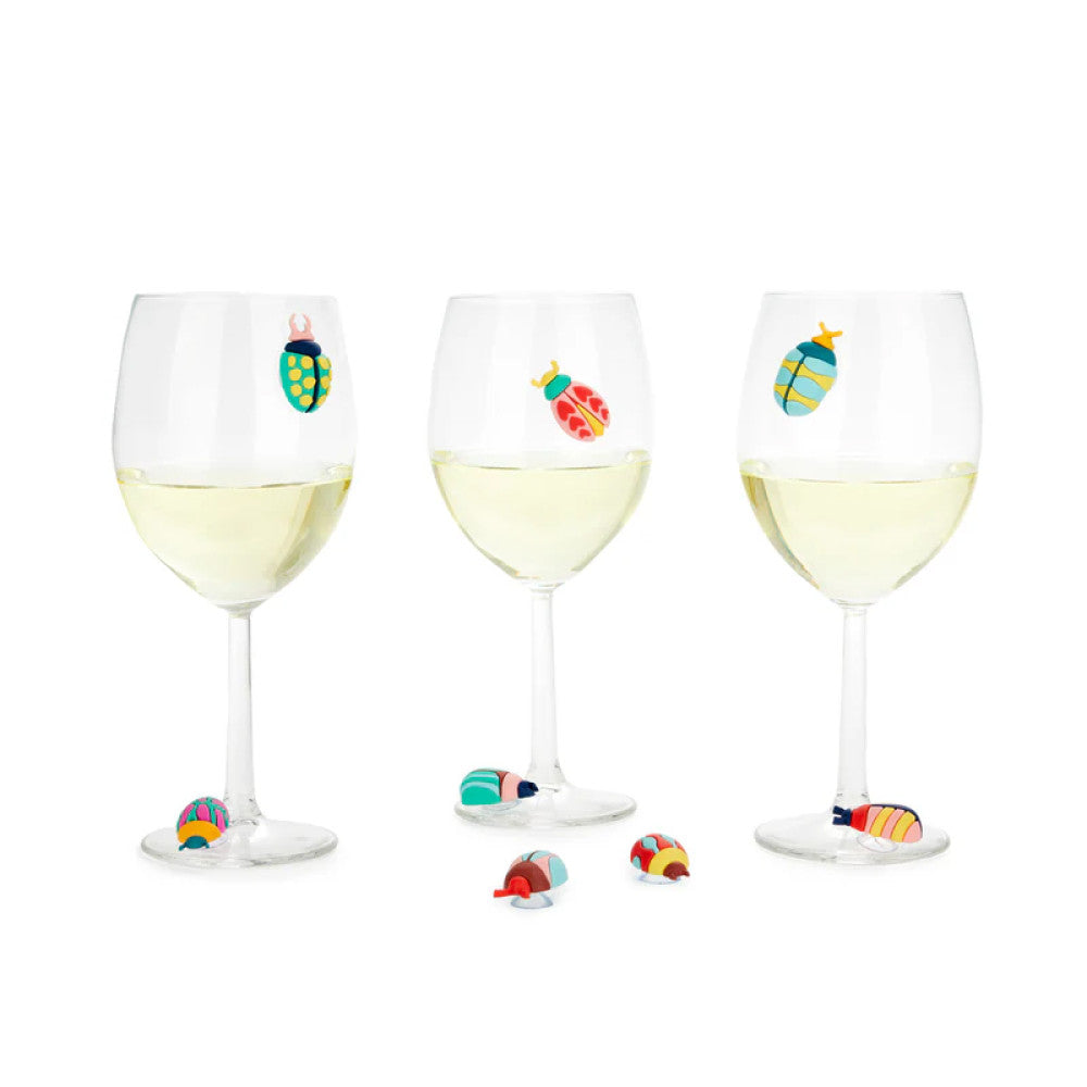 Three wine glasses with beetle markers and beetles displayed on table