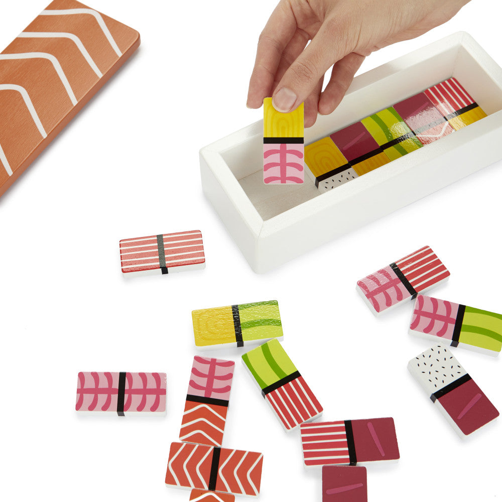 Sushi dominoes scattered with box open on white background