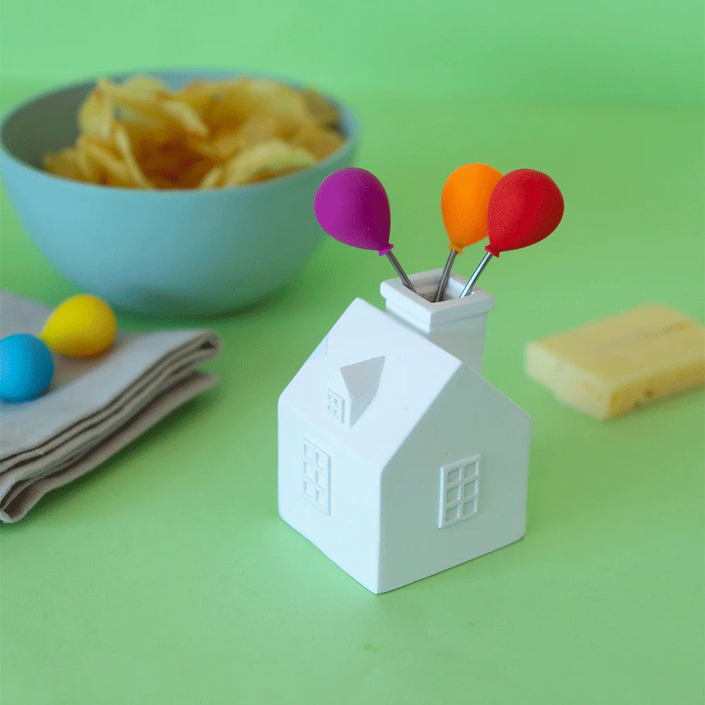 Ceramic balloon house stand with forks displayed on green background