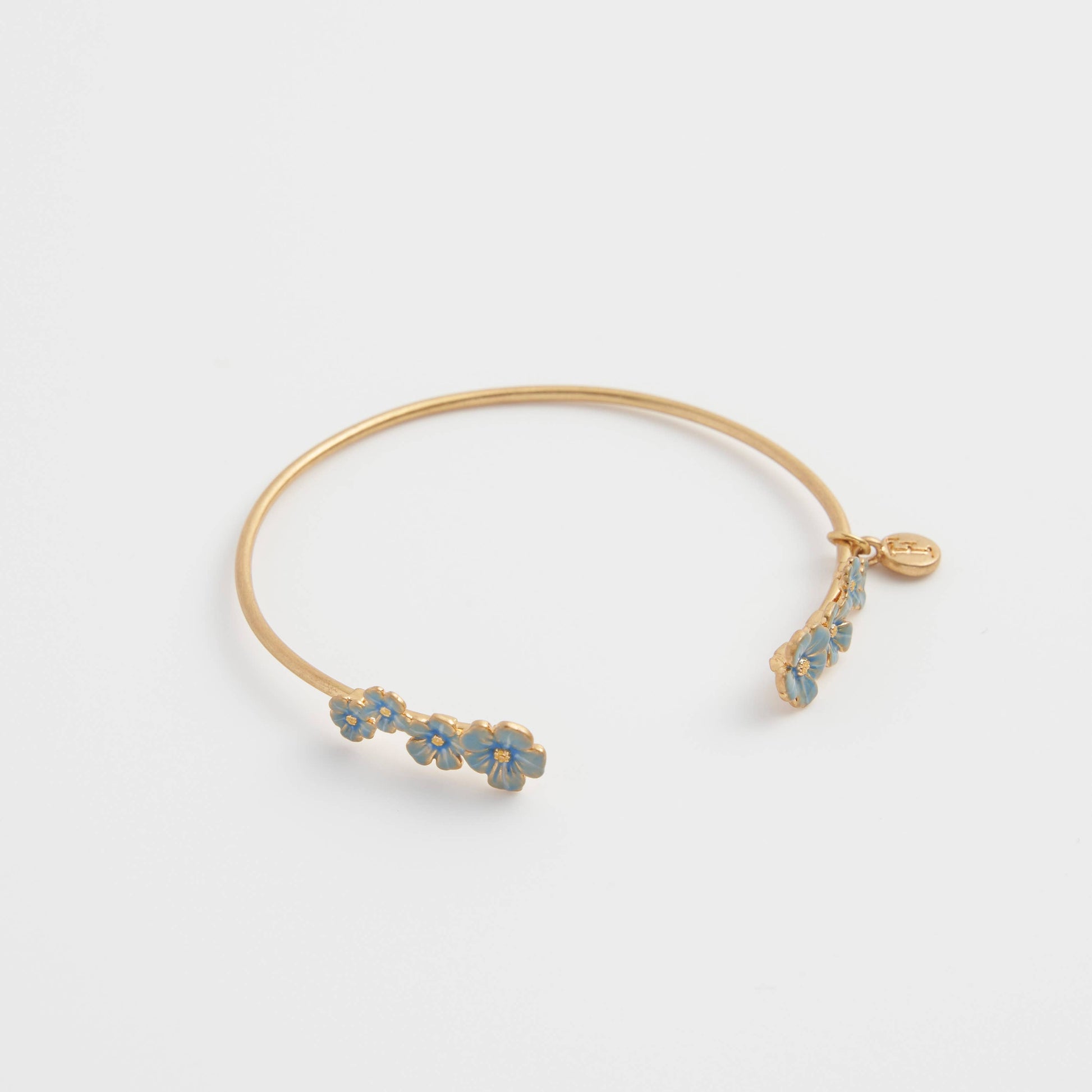 Open gold-plated forget-me-not bangle with blue enamel floral detailing