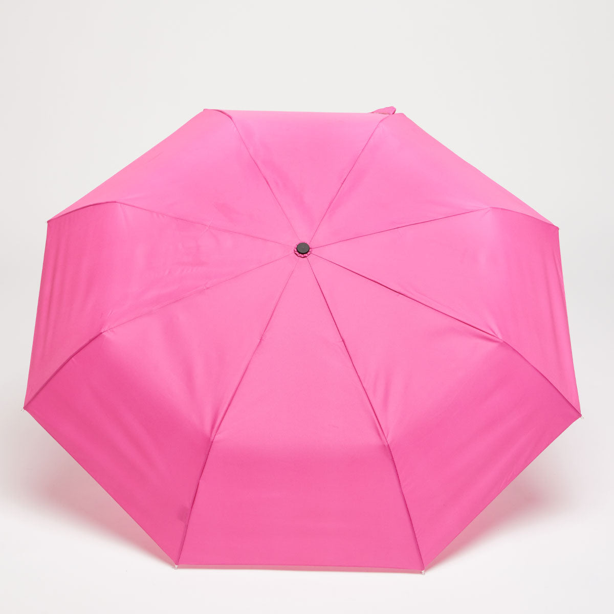 Top-down view of open pink duck umbrella canopy on grey background