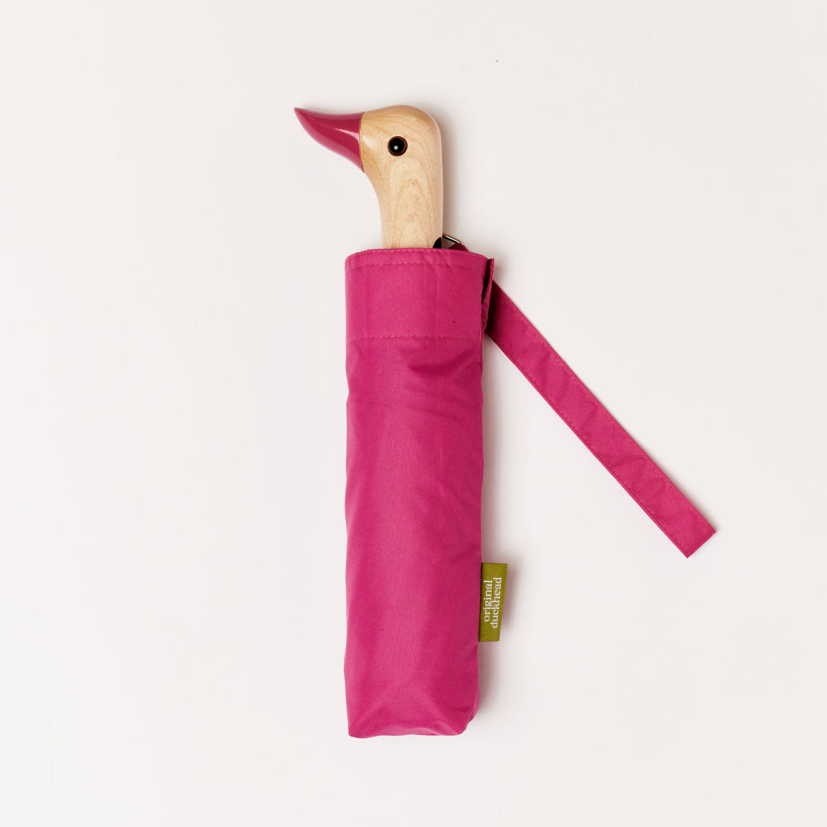 Closed pink duck umbrella flat lay showing wooden duck head handle