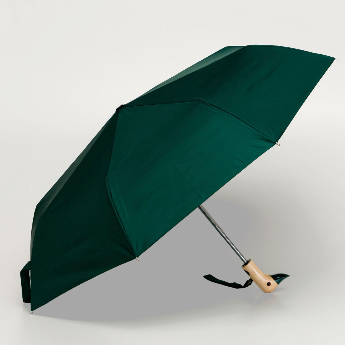 Forest green compact duck umbrella open side view on light background