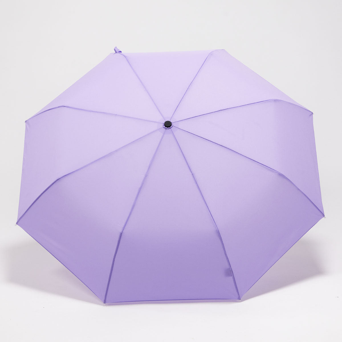 Top-down view of open lilac duck umbrella canopy on grey background