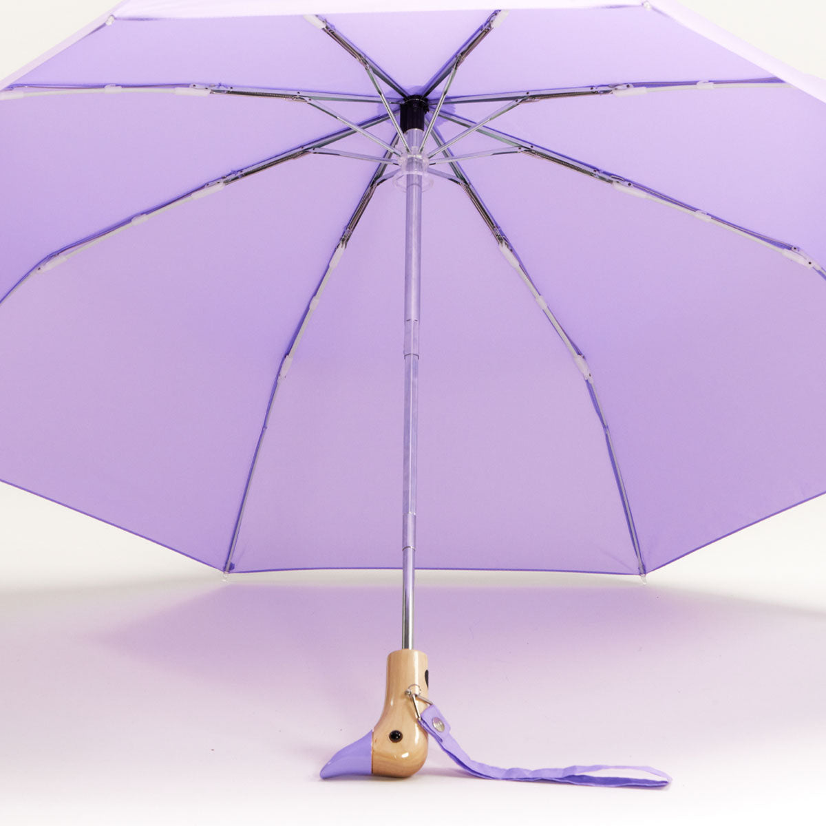 Lilac duck umbrella open from underneath showing ribs and wooden handle