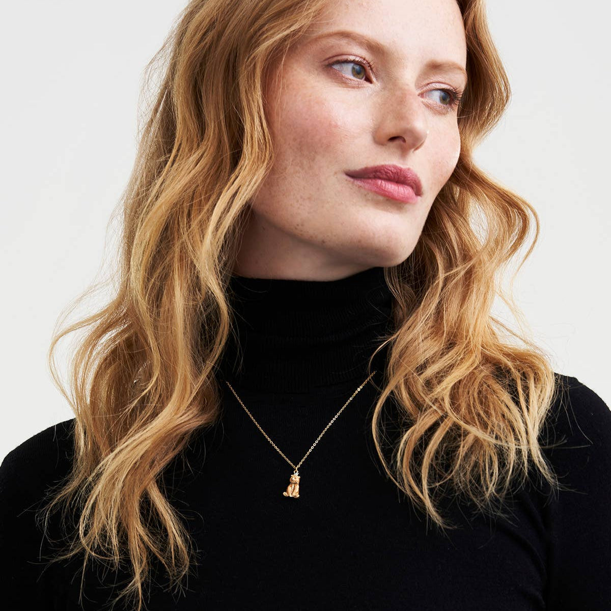 Model wearing Party Bear necklace with black roll neck.