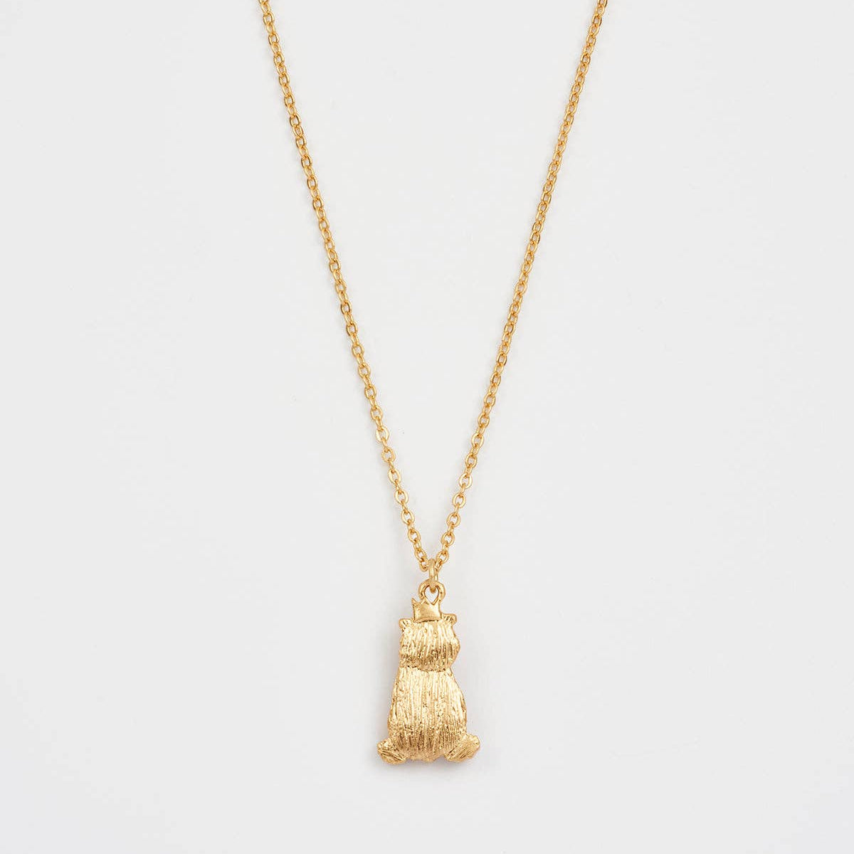 Back view of worn gold Party Bear pendant on chain.