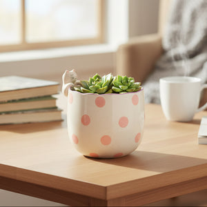 Cream ceramic planter with peeking cat design on white background