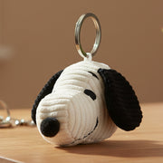 Snoopy head corduroy keyring on wooden surface beige background