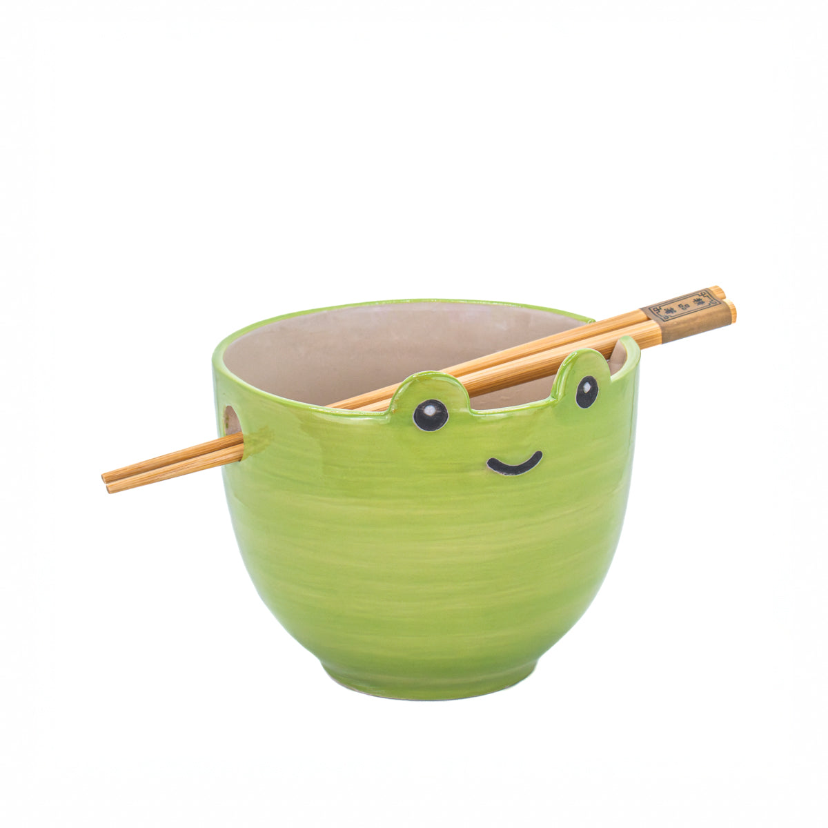 Green ceramic frog noodle bowl with bamboo chopsticks on white background