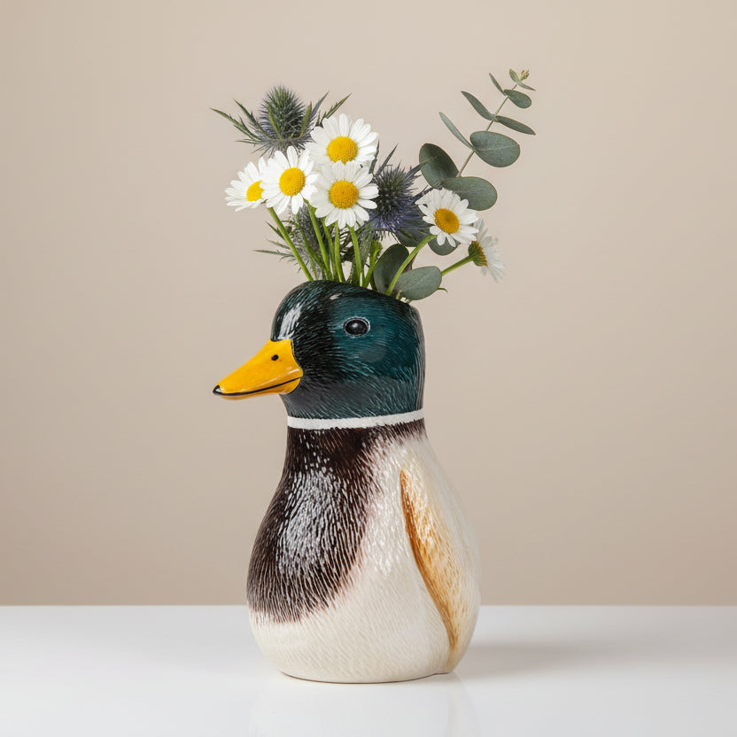 Mallard duck vase with daisies thistles and eucalyptus on beige background