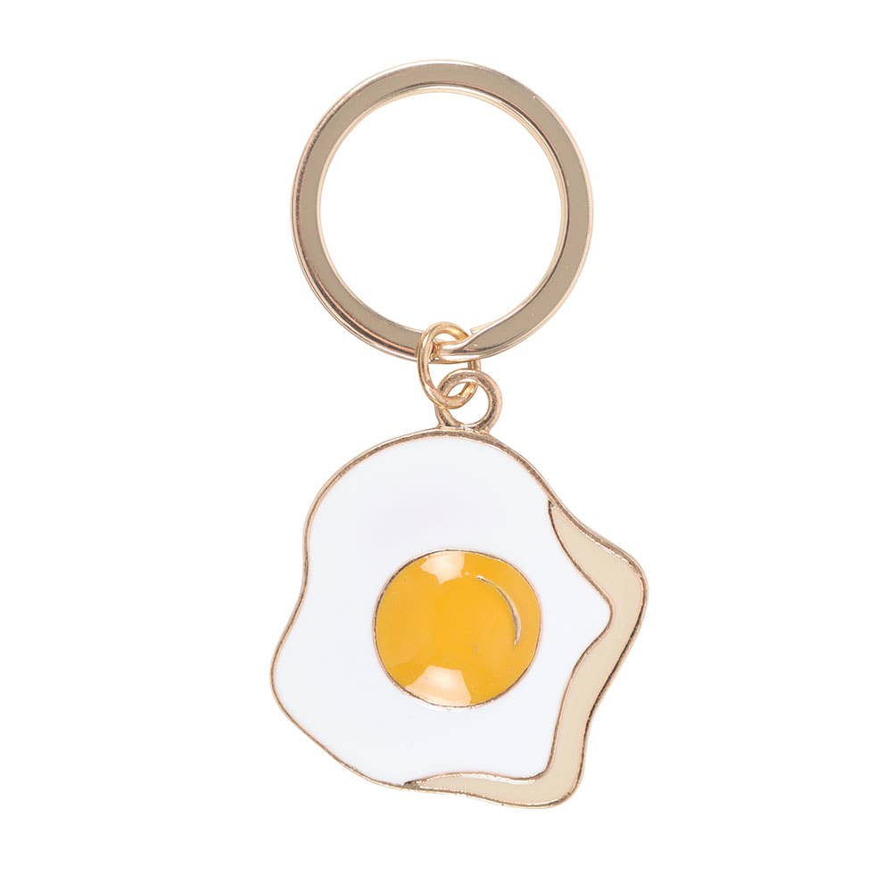 Fried egg enamel charm close-up with gold outline on white background