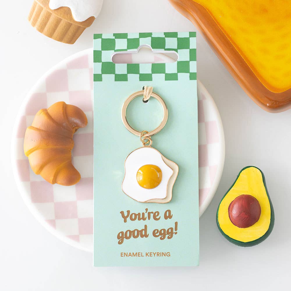 Good egg enamel keyring on mint card styled with food props on pink plate