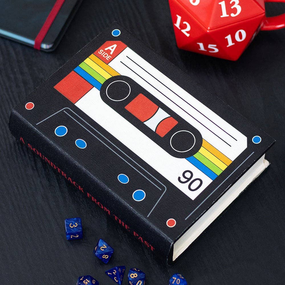 Cassette box on dark background with dice and décor
