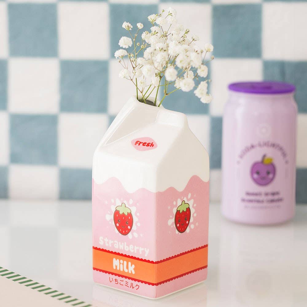 Pink strawberry milk vase with flowers styled on pink surface