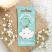 Worry cloud keyring on turquoise card styled on wooden board with flowers