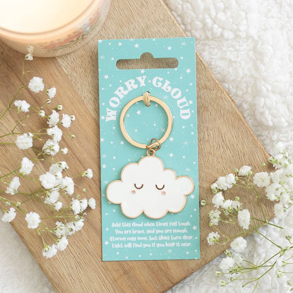 Worry cloud keyring on turquoise card styled on wooden board with flowers