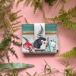 Secret Garden hedgehog purse on pink background with foliage