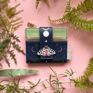 Secret Garden moth purse in navy faux leather on pink background