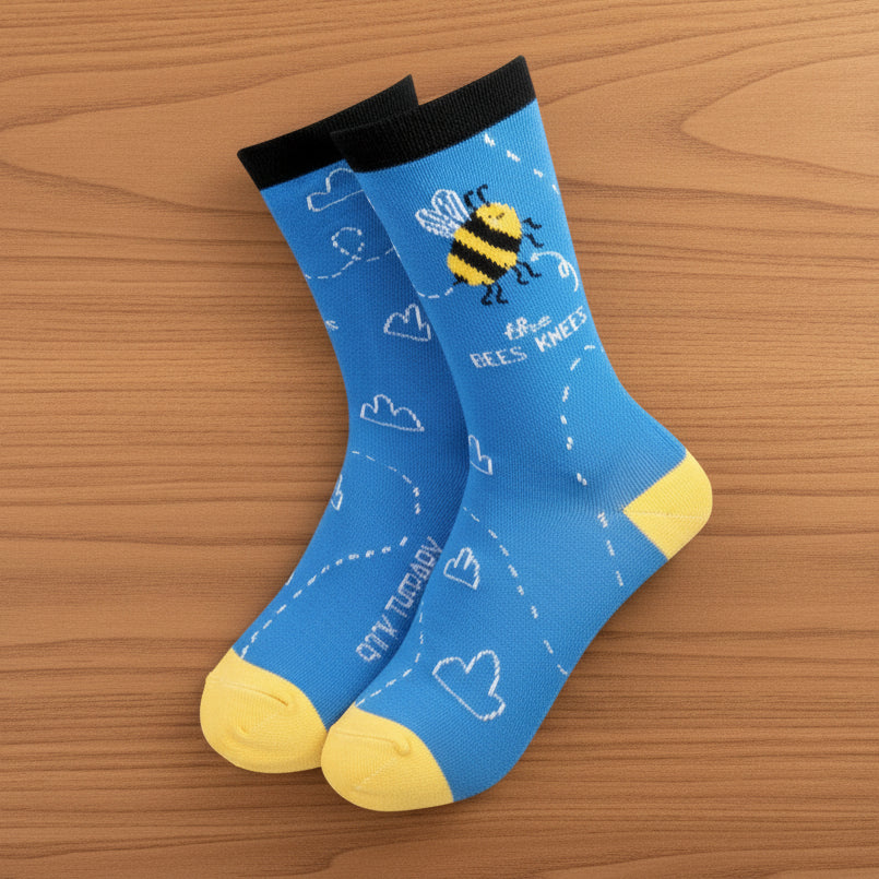 Blue bamboo bees knees socks with bee design on wooden surface