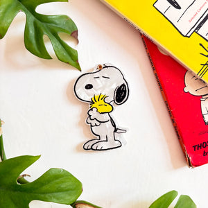 Peanuts compact mirror showing Snoopy hugging Woodstock on white background
