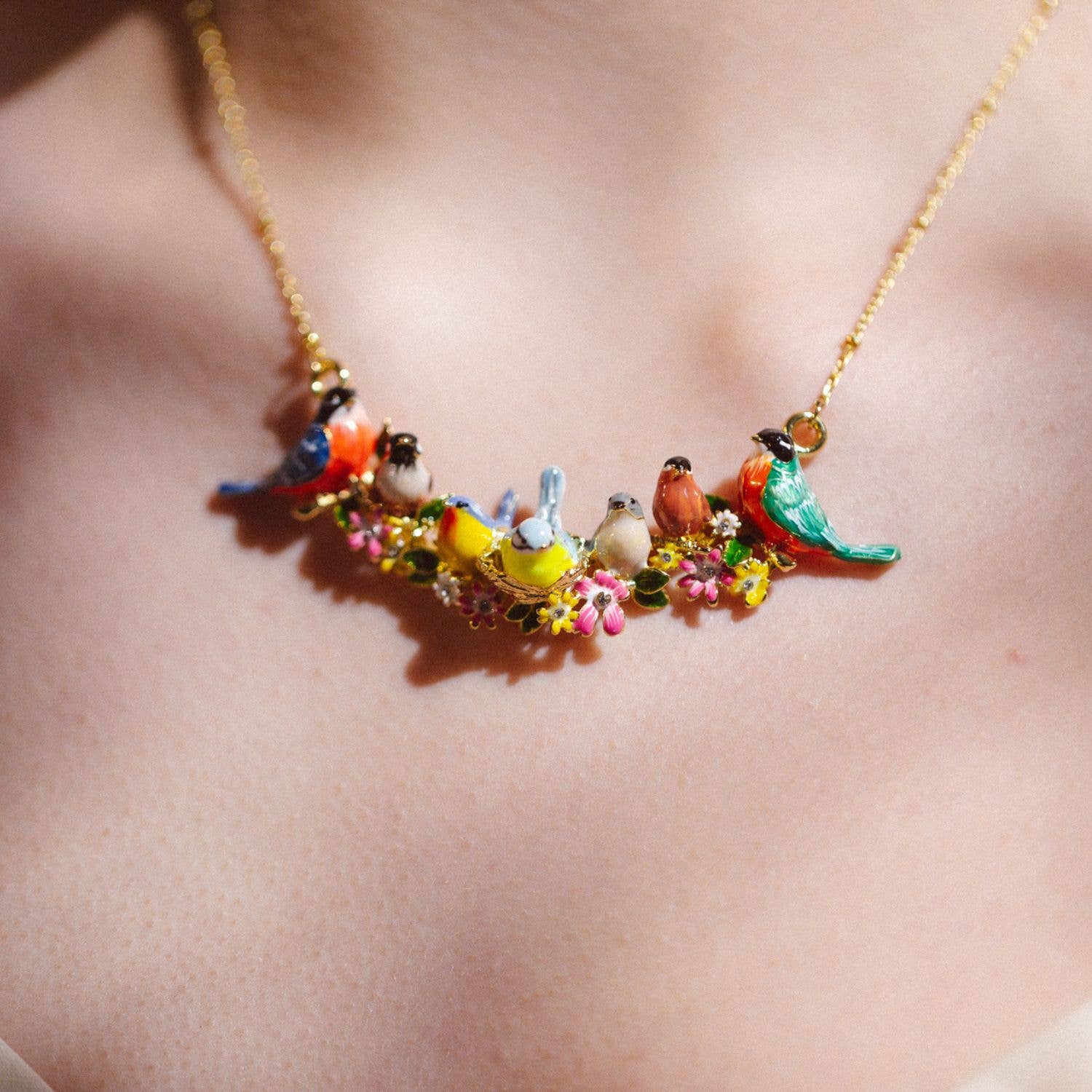 Model wearing Goldcrest Songbird Serenade Necklace showing detailed hand-painted birds.