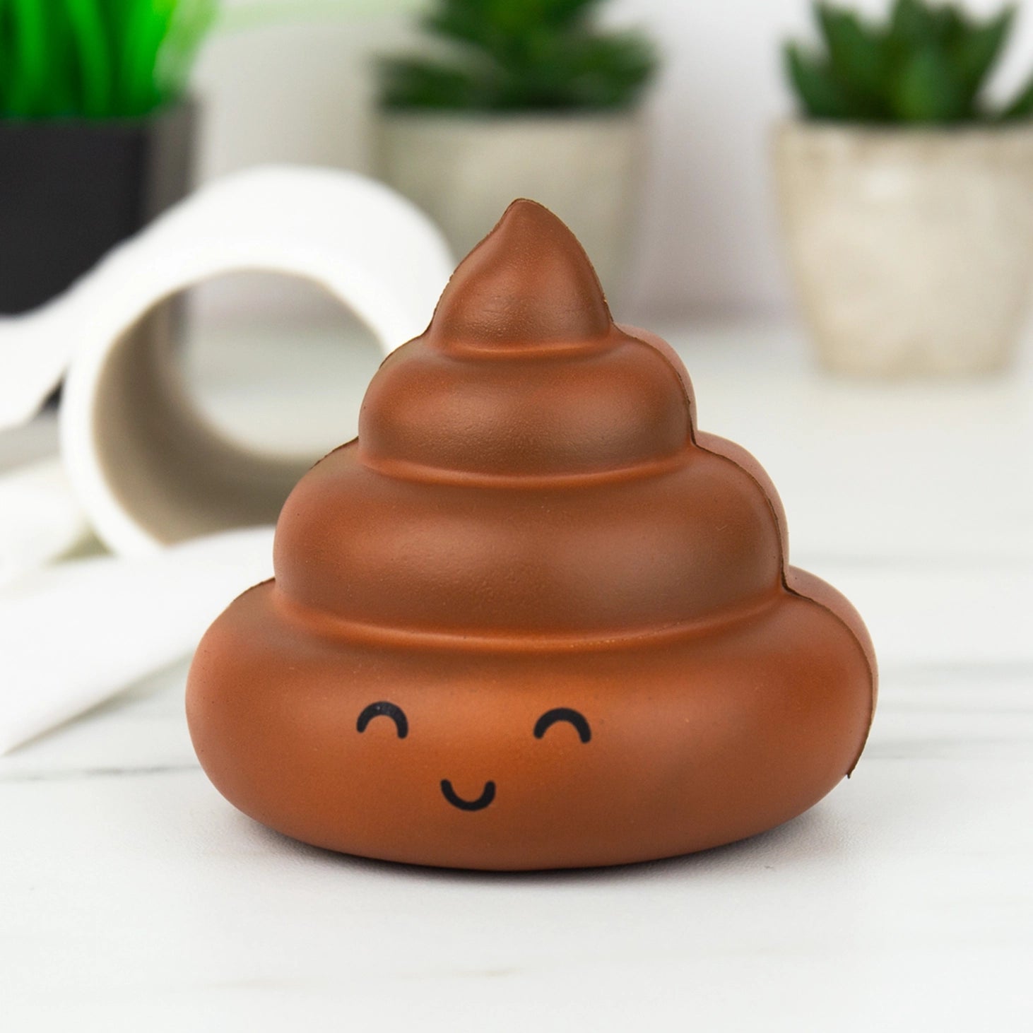 Stress Poo stress toy with smiling face on white surface