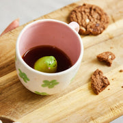 Surprise hidden frog mug filled with tea showing green frog peeking out