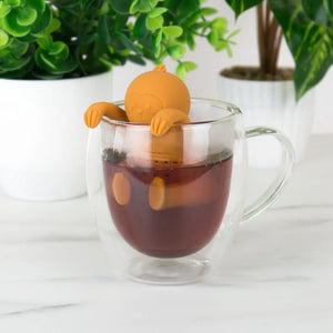 Sloth Tea Infuser hanging on glass mug while steeping tea.