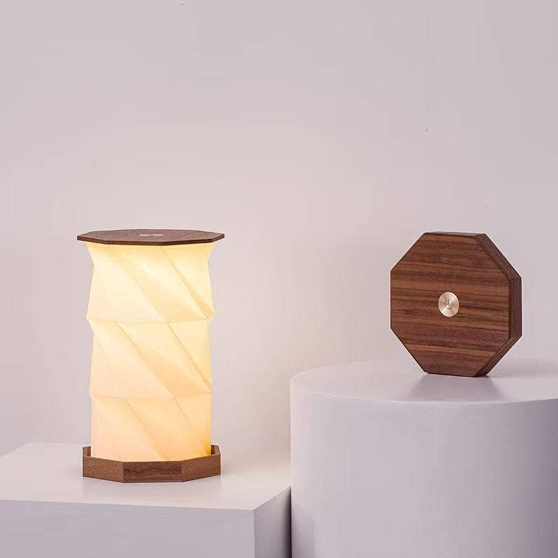 Twist Hexagon lamp in walnut finish on white plinth with folded hexagon lid