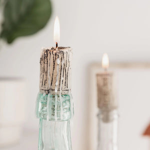 Cork candle burning in a wine bottle – rustic home décor.