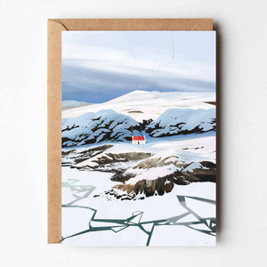 Winter at Croft Cottage greeting card showing illustrated snowy Scottish landscape with croft cottage and kraft envelope.
