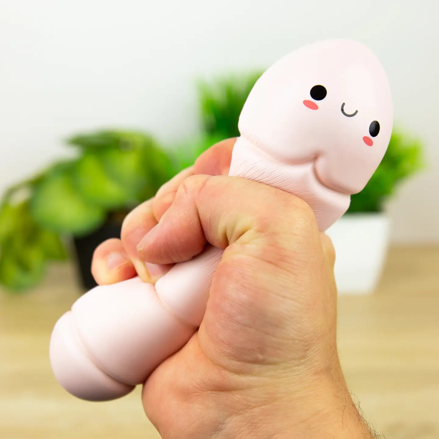 Hand squeezing Willy the Worry Worm squishy stress toy