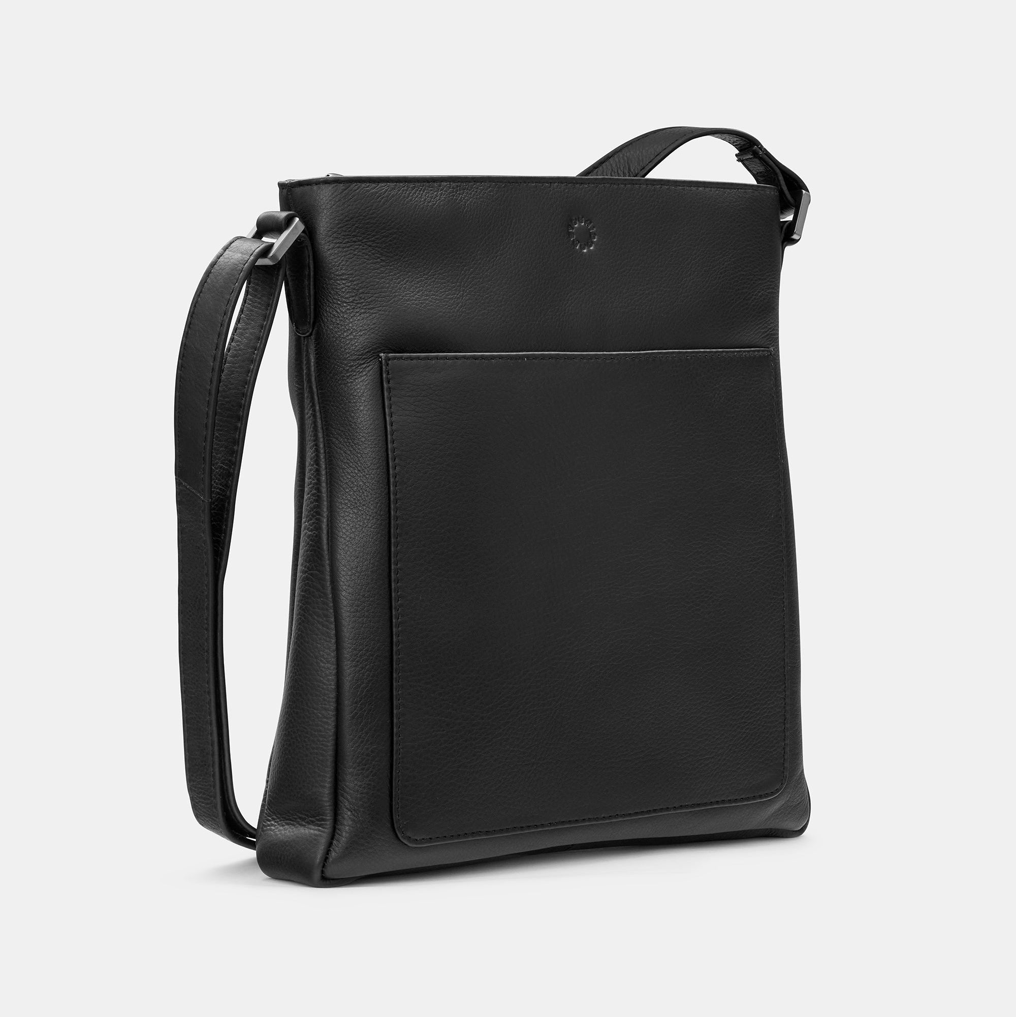 Black leather crossbody bag side view showing front slip pocket on grey background