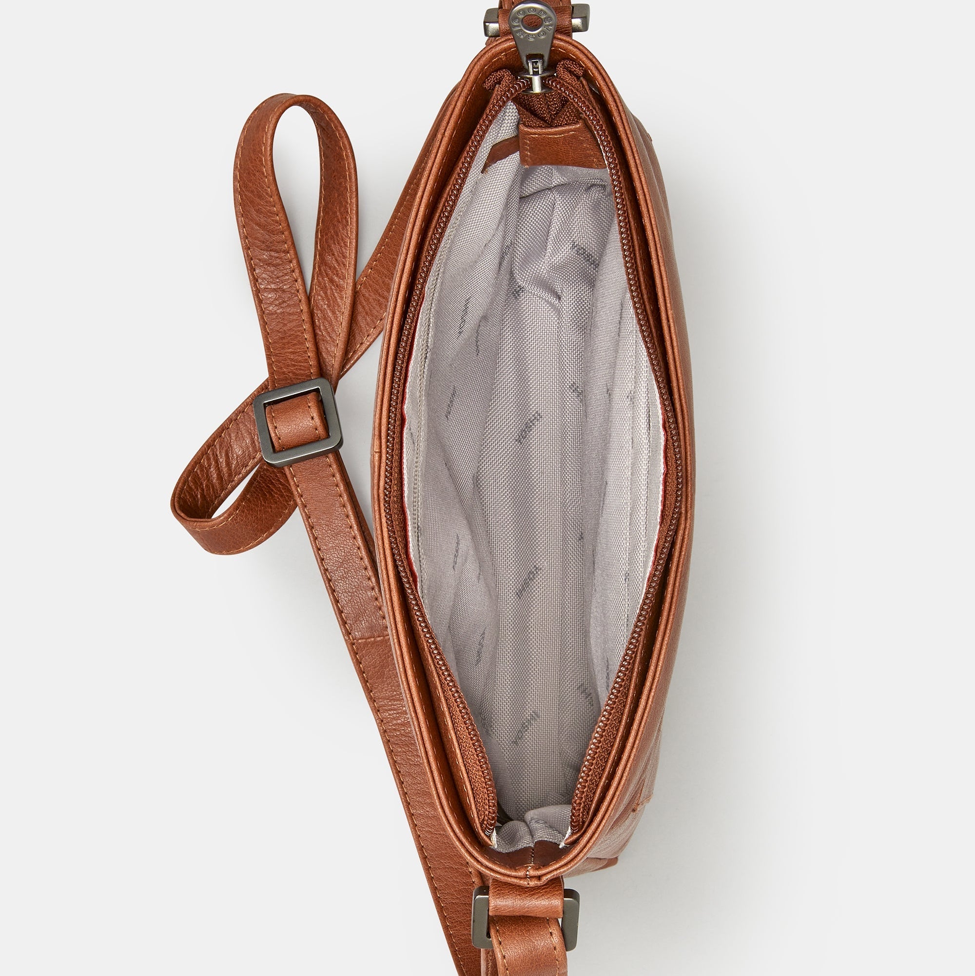 Brown leather crossbody bag overhead view showing grey patterned lining interior